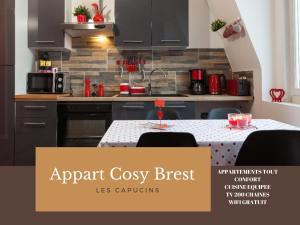 Appart Cosy Brest (les Capucins) في بريست: مطبخ شقة مريح مع طاولة مع كراسي