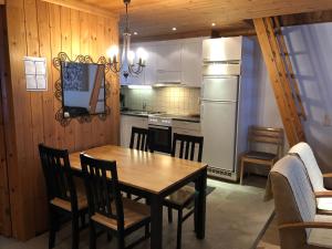 cocina con mesa, sillas y nevera en Ruka Rantaruka 6 en Ruka