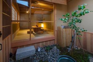 a house with a tree in the middle of a building at Umenoki an Machiya House in Kyoto