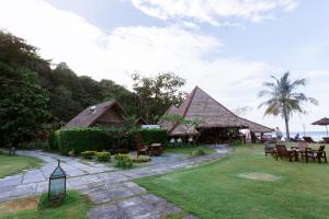 ein Resort mit Tischen und Stühlen im Gras in der Unterkunft Bundhaya Villas in Ko Lipe