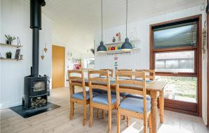 ロッケンにあるStunning Home In Lkken With 3 Bedrooms And Wifiのダイニングルーム(テーブル、薪ストーブ付)