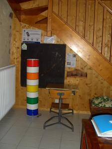 ein Klassenzimmer mit einem Schreibtisch, einer Tafel und einem Tisch in der Unterkunft Cellier de la Fontaine in Saint-Georges-en-Couzan