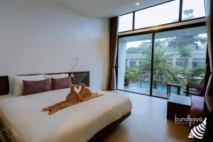 a bedroom with a large bed and a large window at Bundhaya Resort in Ko Lipe