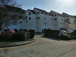 a large white building with cars parked in a parking lot at Ghyll Rigg in Bowness-on-Windermere