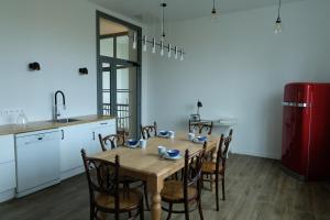 a kitchen with a table with chairs and a red refrigerator at Maison d'hôtes Le 90 in Armentières