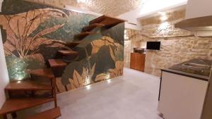 a kitchen with a wall with a mural of plants at B&B il castello suite in Giovinazzo