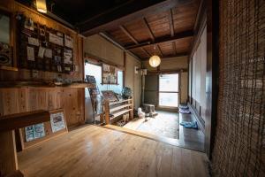 隠岐の島町にある一棟貸し宿Kusuburu House chartered accommodationのウッドフロアのリビングルーム(大きな窓付)