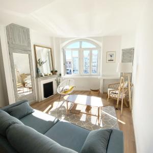 a living room with a blue couch and a table at Le Carnet de Sète et sa vue sur le canal in Sète