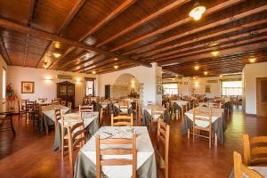 uma sala de jantar com mesas e cadeiras e tectos em madeira em Hotel Plestina Ristorante Pizzeria em Foligno
