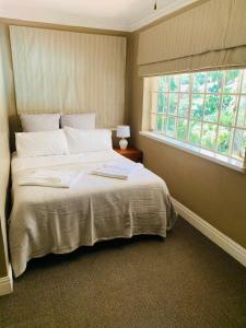a bedroom with a large bed and a window at Firenze in Kloof