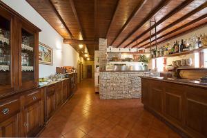uma grande cozinha com armários de madeira e um bar em Hotel Plestina Ristorante Pizzeria em Foligno