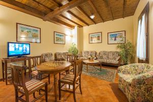 uma sala de estar com uma mesa e cadeiras e uma televisão em Hotel Plestina Ristorante Pizzeria em Foligno