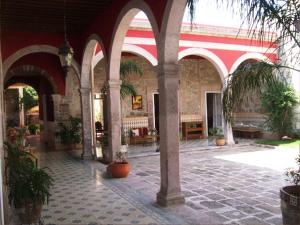 une cour avec des arches et des plantes en pot dans un bâtiment dans l'établissement Casa Limonchelo Hotel B&B, à Morelia