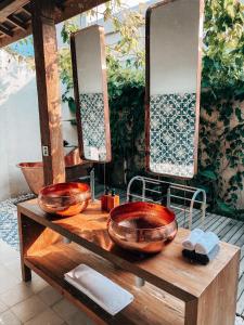 a bathroom with two sinks and mirrors on a table at Villa Victoria Nusa Penida in Nusa Penida