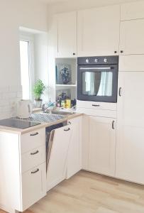 a kitchen with white cabinets and a stove top oven at Sopot Apartament in Sopot