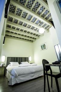 a bedroom with a bed and a table with a chair at Hotel Boutique Casas de Santa Cruz in Seville