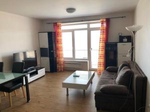 a living room with a couch and a table at L&B Lake view modern apartment in Lipno nad Vltavou