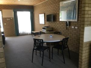 a dining room with a table and chairs in a room at Sunrise Motel in Barooga