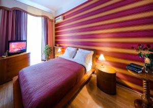a bedroom with a bed and a tv and a window at Boutique Apart-Hotel Sherborne in Kyiv