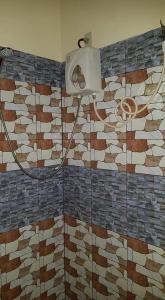 a bathroom with a shower with mosaic tiles on the wall at Paco's Garden Home Stay in Mambajao +70 photos