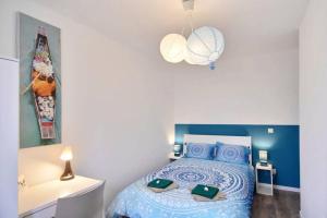 a bedroom with a blue and white bed and a lamp at Le Grand Joliette Marseille "experience-immo" in Marseille