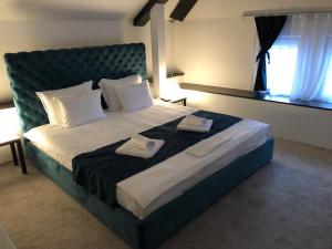 um quarto com uma cama grande com duas toalhas em Attico Spa em Kragujevac
