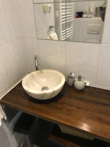 a bathroom with a white sink on a wooden counter at Kampen NL 28-1 in Kampen