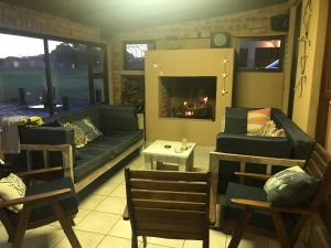 a living room with a couch and a fireplace at Sibiya Guest House in Sodwana Bay