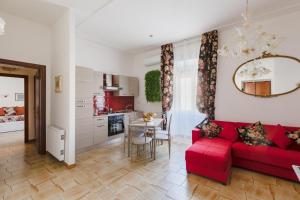 Il comprend un salon avec un canapé rouge et une cuisine. dans l'établissement My Home in San Pietro, à Rome