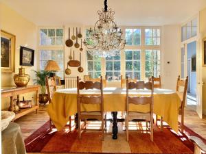 a dining room with a table and a chandelier at Le Clos Saluces in Avignon