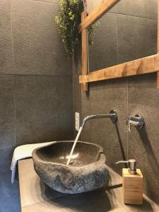 La salle de bains est pourvue d'un lavabo en pierre avec un robinet. dans l'établissement Bico das flores, à Praia de Mira