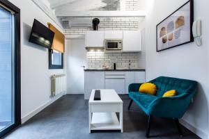 a living room with a green couch and a table at Apartamentos Hervás Suites in Hervás