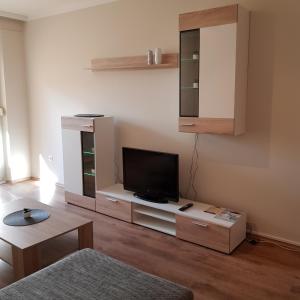 a living room with a flat screen tv on a stand at Chill Apartman in Komárom