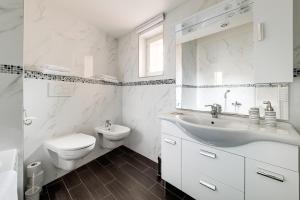 a white bathroom with a sink and a toilet at Koruna Hotel in Prague