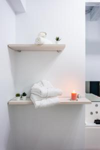 un estante con toallas y una vela en la pared en Apartamentos Hervás Suites en Hervás