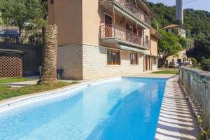 a swimming pool in front of a house at A Casa di Mila - Appartamento con piscina in Sori