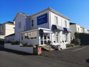 a white building with a blue sign on it at Harmony Bed and Breakfast in Torquay
