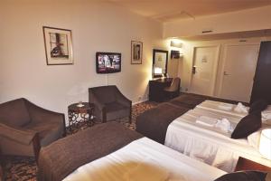 une chambre d'hôtel avec deux lits et une chaise dans l'établissement Ariston Hotell, à Lidingö