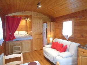 una sala de estar con sofá y una cama en una cabaña en Domaine Moulin d'Elemiah, en Gémozac