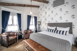 1 Schlafzimmer mit einem Bett und 2 Stühlen in der Unterkunft Zamarin Hotel & Spa in Zichron Ja’akow