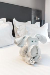 a stuffed elephant is sitting on a bed at La Table de Gustave in Ornans