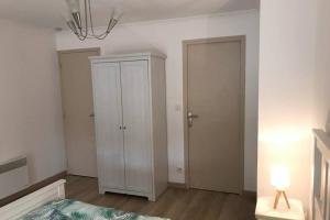 een slaapkamer met een witte kast en een deur bij Au pied du phare... in Honfleur