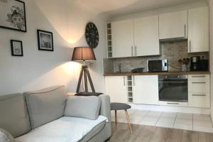 een woonkamer met een bank en een keuken bij Au pied du phare... in Honfleur