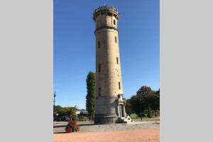 een vuurtoren in een park met een blauwe lucht bij Au pied du phare... in Honfleur