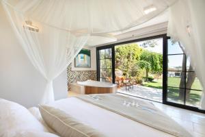 a bedroom with a bed and a large window at Alacati Kapari Hotel - Special Category in Alaçatı