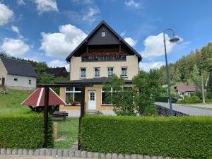 Biały dom z czarnym dachem w obiekcie Pension Weiberwirtschaft in Pobershau w mieście Pobershau
