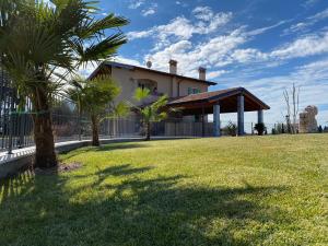 a house with a fence and a grass yard at Villa Poggio Bardolino in Bardolino