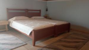 a bed in a bedroom with a wooden frame at Attic of Mary in Nea Roda