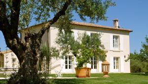 a large white house with a tree in front of it at La Bastide d'Andrea in Martignargues