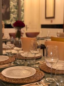 a table with wine glasses and plates on it at Hotel Emblemático Agáldar in Gáldar